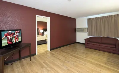 a living room with a flat screen tv and a couch at Red Roof Inn Lancaster Strasburg in Lancaster