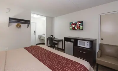 a small hotel room with a bed and a desk at Red Roof Inn Lancaster Strasburg in Lancaster