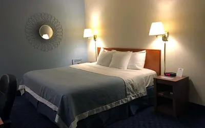 a hotel room with a bed and a table with a clock at Mainstreet Inn in Doylestown