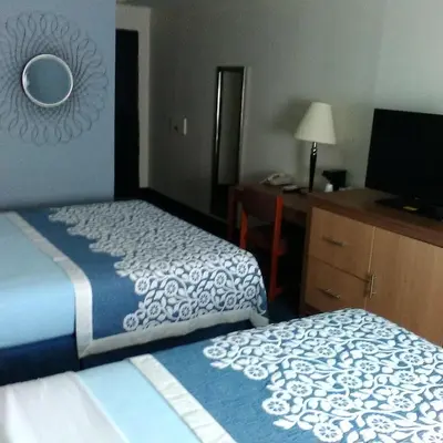 a hotel room with two beds and a desk and a television at Mainstreet Inn in Doylestown
