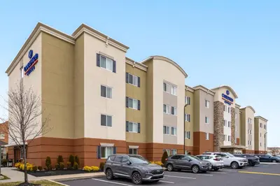 a building with cars parked in a parking lot at Candlewood Suites Philadelphia - Airport Area by IHG in Chester