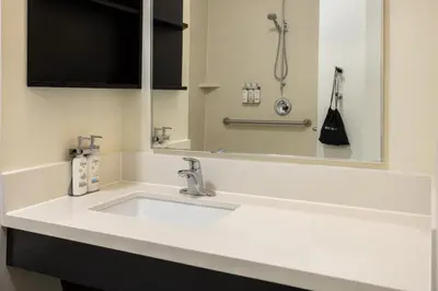 a bathroom with a white sink and a mirror at Candlewood Suites Philadelphia - Airport Area by IHG in Chester