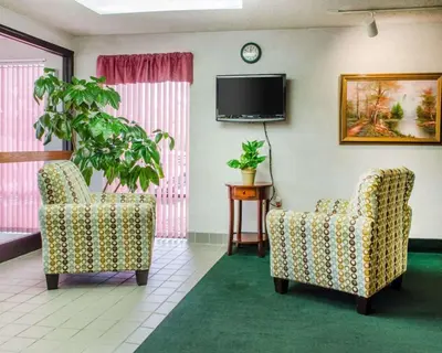 a living room with two chairs and a tv at Econo Lodge Mifflintown in Mifflintown