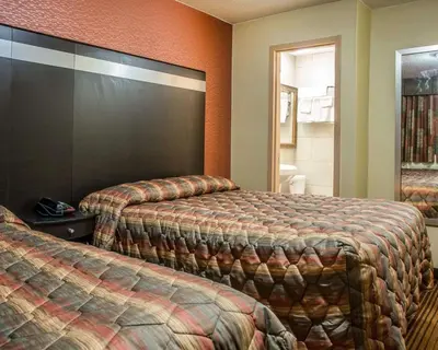 a hotel room with two beds and a mirror at Rodeway Inn Belleville in Belleville