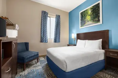 a hotel room with a bed and a chair at Days Inn by Wyndham Philadelphia Convention Center in Philadelphia