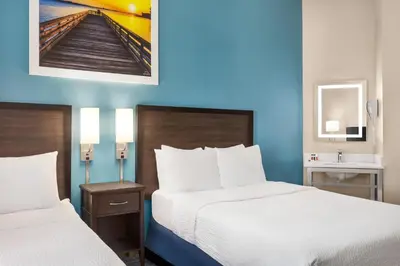 two beds in a hotel room with blue walls at Days Inn by Wyndham Philadelphia Convention Center in Philadelphia