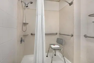 a shower with a chair in a bathroom at Days Inn by Wyndham Philadelphia Convention Center in Philadelphia