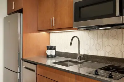 a kitchen with a sink and a microwave at Homewood Suites By Hilton Wilmington Downtown in Wilmington