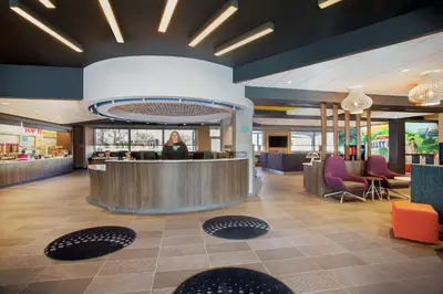 a lobby with a woman standing at a counter at Tru By Hilton Audubon Valley Forge in Audubon
