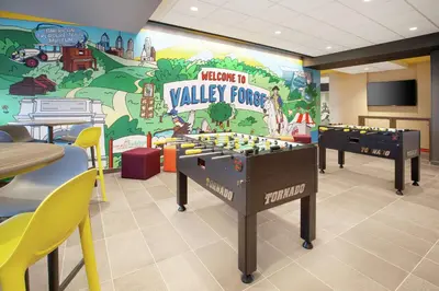 a childrens play room with two foosball tables in front of a wall at Tru By Hilton Audubon Valley Forge in Audubon