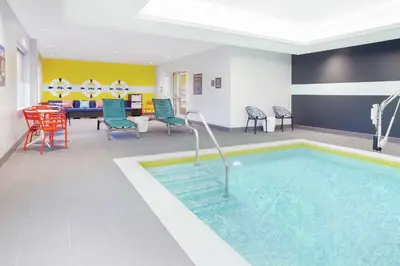 a pool in a hotel room with chairs and a table at Tru By Hilton Audubon Valley Forge in Audubon