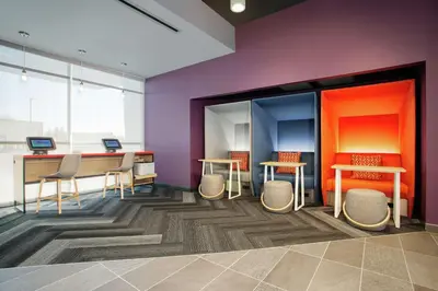 a room with two tables and chairs and purple walls at Tru By Hilton Audubon Valley Forge in Audubon