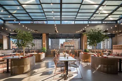 a restaurant with tables and chairs and large windows at Motto by Hilton Philadelphia Rittenhouse Square in Philadelphia