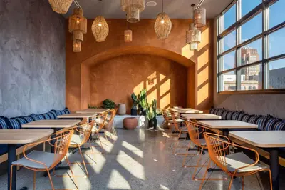 a row of tables and chairs in a room with windows at Motto by Hilton Philadelphia Rittenhouse Square in Philadelphia