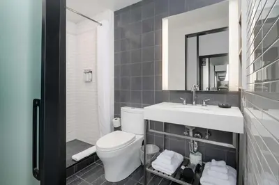 a bathroom with a toilet and a sink and a mirror at Motto by Hilton Philadelphia Rittenhouse Square in Philadelphia