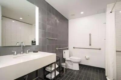 a bathroom with a sink and a toilet and a mirror at Motto by Hilton Philadelphia Rittenhouse Square in Philadelphia