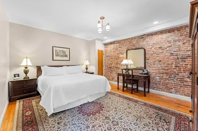 a bedroom with a bed and a brick wall at Penn's View Hotel Philadelphia in Philadelphia