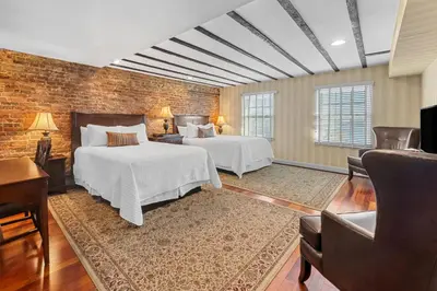 a bedroom with two beds and a brick wall at Penn's View Hotel Philadelphia in Philadelphia