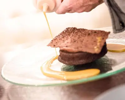 a person is making a sandwich on a plate at The Desmond Hotel Malvern, a DoubleTree by Hilton in Malvern