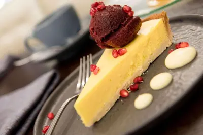 a piece of cake on a plate with a fork at The Desmond Hotel Malvern, a DoubleTree by Hilton in Malvern