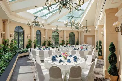 a banquet hall with white tables and chairs and chandeliers at The Desmond Hotel Malvern, a DoubleTree by Hilton in Malvern