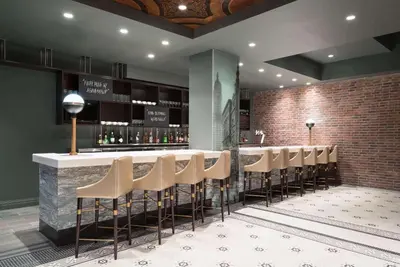 a bar with a bunch of stools in a room at TRYP by Wyndham Newark Downtown in Newark