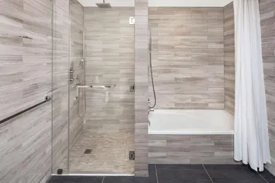 a bathroom with a tub and a shower with a shower curtain at Hilton Club The Quin New York in New York