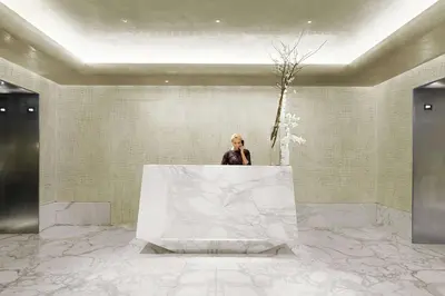 a woman standing behind a table in a lobby at Hilton Club The Quin New York in New York
