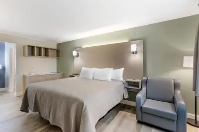 a hotel room with a bed and a chair at Quality Inn Smoketown - Lancaster Area in Smoketown