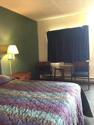 a hotel room with a bed and a table and chairs at Hudson Plaza Motel Bayonne Jersey City in Jersey City