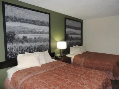 a hotel room with two beds and two pictures on the wall at Super 8 by Wyndham Mifflinville Near Bloomsburg in Mifflinville