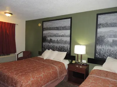 a hotel room with two beds and two posters on the wall at Super 8 by Wyndham Mifflinville Near Bloomsburg in Mifflinville