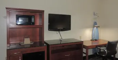 a hotel room with a desk with a television and a deskictericter at Super 8 by Wyndham Mifflinville Near Bloomsburg in Mifflinville