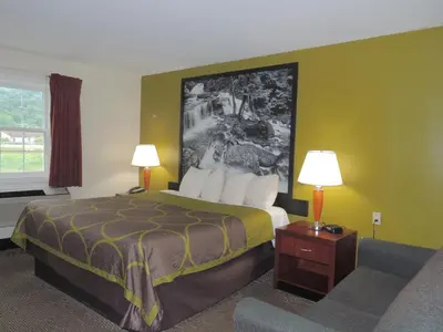 a hotel room with a bed and a couch at Super 8 by Wyndham Mifflinville Near Bloomsburg in Mifflinville