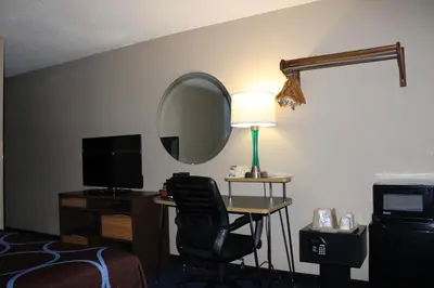 a hotel room with a desk with a chair and a mirror at Super 8 by Wyndham East Stroudsburg - Poconos in East Stroudsburg