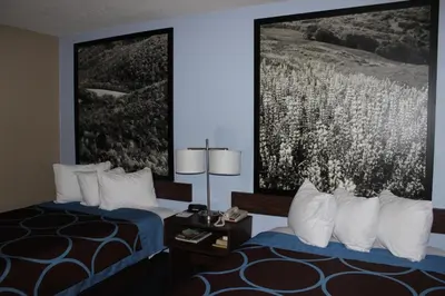 a hotel room with two beds and a painting on the wall at Super 8 by Wyndham East Stroudsburg - Poconos in East Stroudsburg