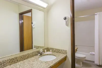 a bathroom with a sink and a toilet and a mirror at Super 8 by Wyndham East Stroudsburg - Poconos in East Stroudsburg