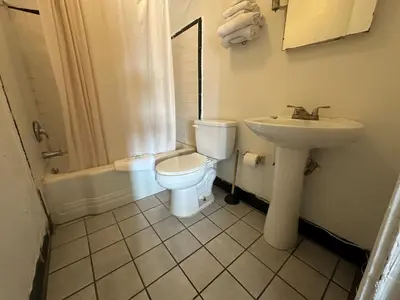 a bathroom with a toilet and a sink at Mark Twain Motor Inn in Elmira