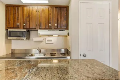 a kitchen with wooden cabinets and a sink at Best Western PLUS Morristown Inn-Florham Park in Morristown