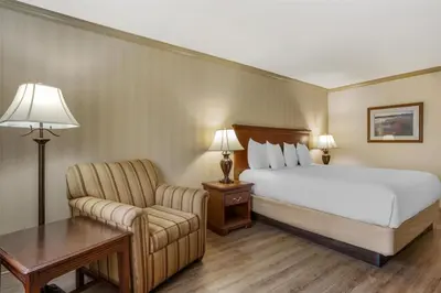 a hotel room with a bed and a chair at Best Western PLUS Morristown Inn-Florham Park in Morristown