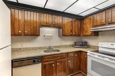 a kitchen with wooden cabinets and a sink at Best Western PLUS Morristown Inn-Florham Park in Morristown