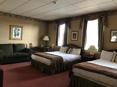 a hotel room with two beds and a couch at Waynebrook Inn in Honey Brook