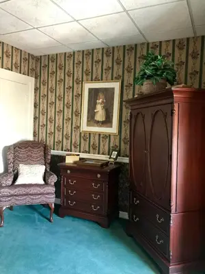 a room with a dresser and a cabinet and a chair at Waynebrook Inn in Honey Brook