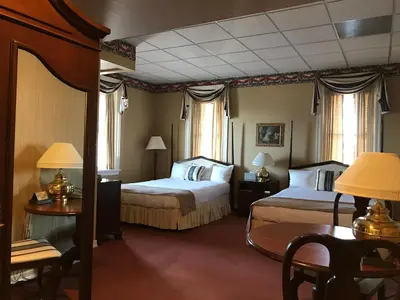 a hotel room with two beds and a table at Waynebrook Inn in Honey Brook