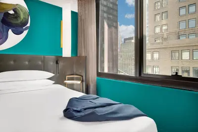 a bed in a room with a large window at Hyatt Centric Midtown 5th Avenue New York in New York