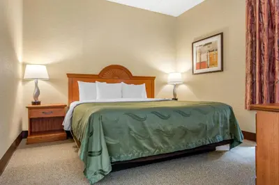 a hotel room with a bed and two lamps at Quality Inn & Suites Mansfield in Mansfield