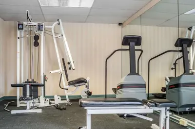 a gym with two tread machines and a mirror at Quality Inn & Suites Mansfield in Mansfield