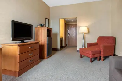 a hotel room with a television and a chair at Quality Inn & Suites Mansfield in Mansfield