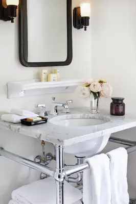 a bathroom with a sink and a mirror and towels at The High Line Hotel in New York