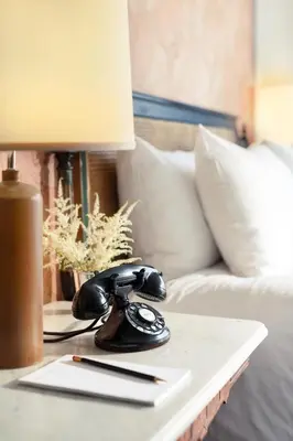 a telephone on a table next to a bed at The High Line Hotel in New York
